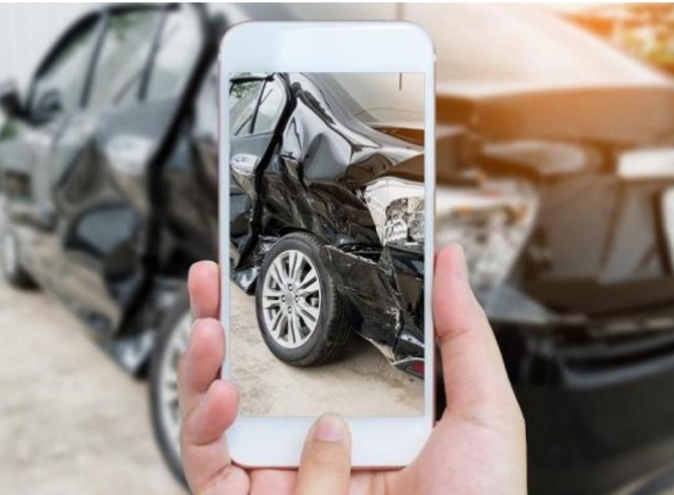 Teléfono celular tomando foto al vehículo dañado